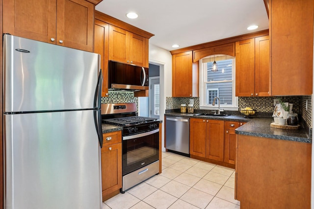 3212 Kentucky Ave S, Saint Louis Park, MN 55426 - kitchen with appliances with stainless steel finishes, dark countertops, decorative backsplash, brown cabinets, and light tile patterned floors