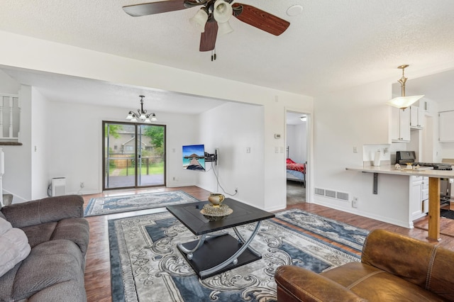 2715 90th Ln NE, Blaine, MN 55449 - living room featuring wood finished floors, a textured ceiling, a chandelier, and ceiling fan