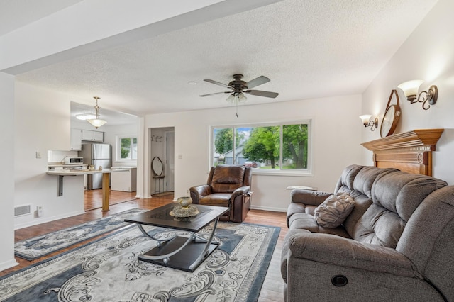 2715 90th Ln NE, Blaine, MN 55449 - living room with healthy amount of natural light, light wood-style flooring, a ceiling fan, and a textured ceiling