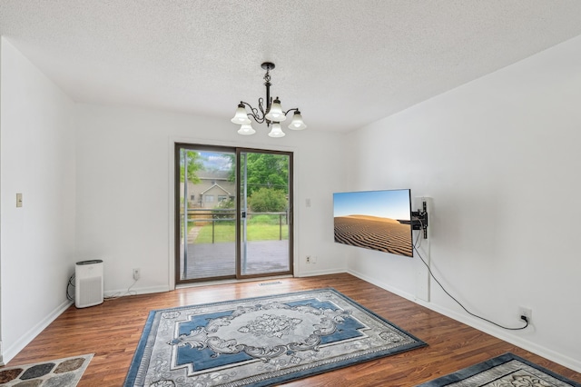 2715 90th Ln NE, Blaine, MN 55449 - dining area featuring a chandelier, wood finished floors, and a textured ceiling