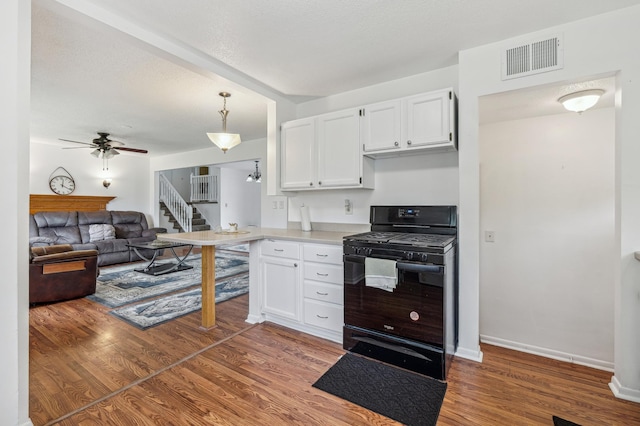2715 90th Ln NE, Blaine, MN 55449 - kitchen with gas stove, white cabinets, wood finished floors, and a ceiling fan