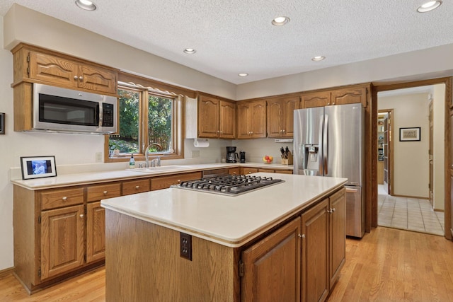 10910 38th Ave N, Plymouth, MN 55441 - kitchen featuring stainless steel appliances, brown cabinets, light countertops, a center island, and a textured ceiling