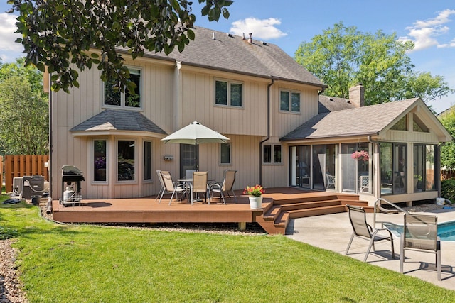 10910 38th Ave N, Plymouth, MN 55441 - rear view of property featuring a sunroom, a shingled roof, a deck, and a chimney