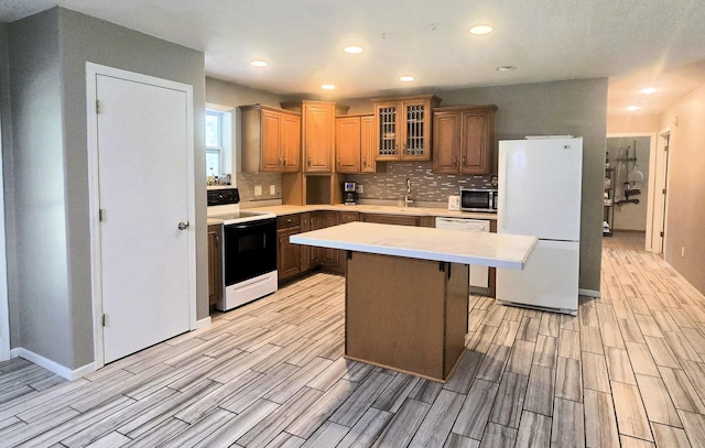 17544 366th St, Bagley, MN 56621 - kitchen featuring white appliances, wood tiled floors, light countertops, a kitchen bar, and decorative backsplash