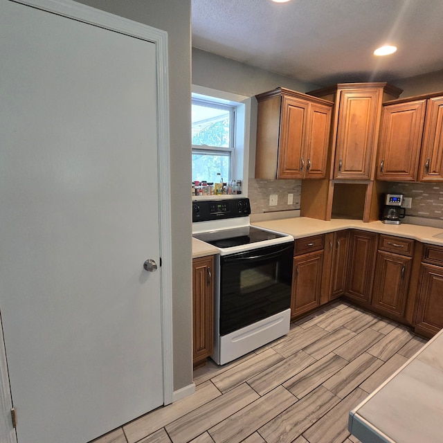 17544 366th St, Bagley, MN 56621 - kitchen featuring white range with electric stovetop, decorative backsplash, wood finish floors, light countertops, and recessed lighting