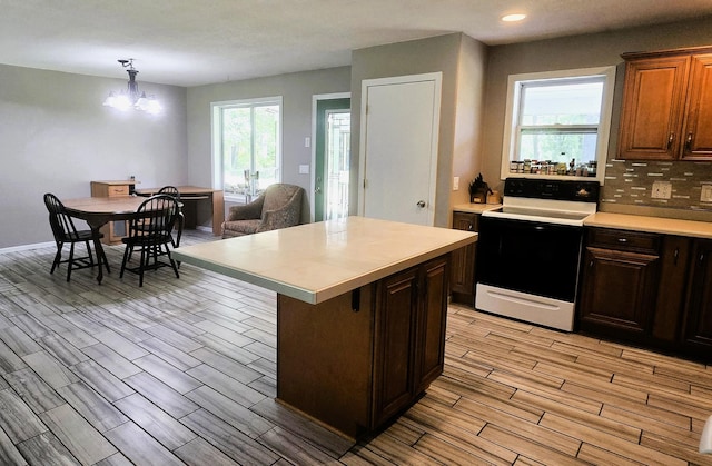 17544 366th St, Bagley, MN 56621 - kitchen featuring white electric stove, light countertops, light wood finished floors, backsplash, and recessed lighting