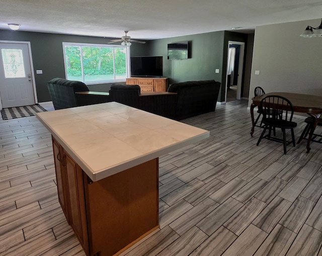 17544 366th St, Bagley, MN 56621 - kitchen featuring open floor plan, wood finish floors, a ceiling fan, and tile countertops