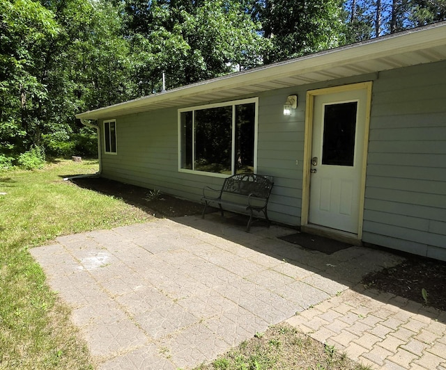 17544 366th St, Bagley, MN 56621 - doorway to property featuring a patio and a lawn
