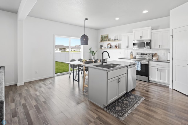 1030 Albert Dr W, West Fargo, ND 58078 - kitchen with stainless steel appliances, wood finished floors, open shelves, tasteful backsplash, and recessed lighting