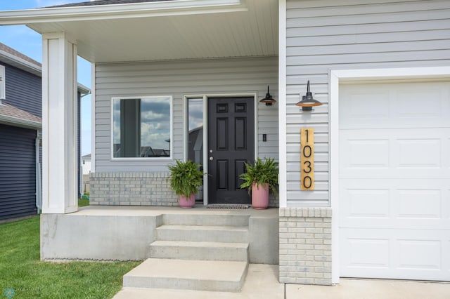 1030 Albert Dr W, West Fargo, ND 58078 - view of exterior entry featuring a porch and a garage