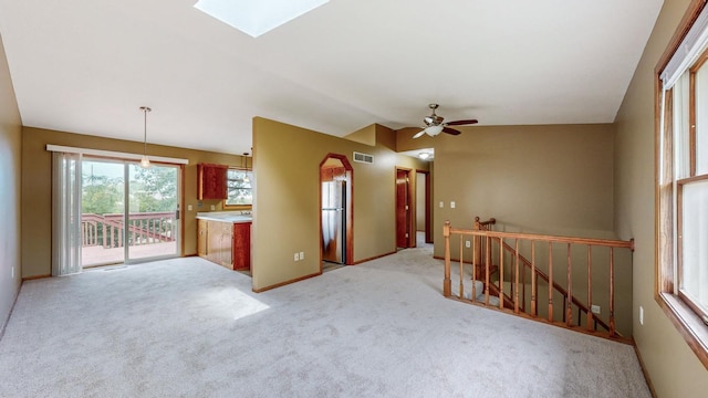 4019 Baffin Ln NE, Rochester, MN 55906 - empty room with a ceiling fan, light carpet, vaulted ceiling, and a skylight