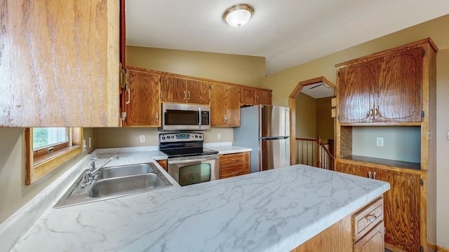 4019 Baffin Ln NE, Rochester, MN 55906 - kitchen with stainless steel appliances, light countertops, vaulted ceiling, a peninsula, and brown cabinetry