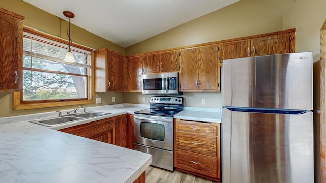 4019 Baffin Ln NE, Rochester, MN 55906 - kitchen with appliances with stainless steel finishes, vaulted ceiling, light countertops, brown cabinetry, and pendant lighting