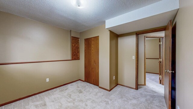 4019 Baffin Ln NE, Rochester, MN 55906 - unfurnished bedroom featuring light carpet, a closet, and a textured ceiling