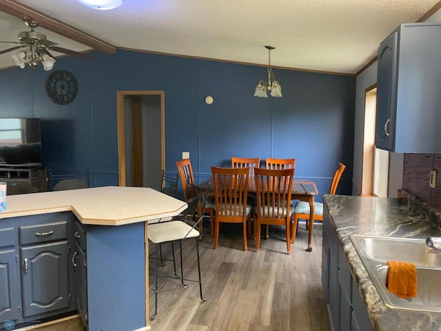 11 Horseshoe Bnd, Horace, ND 58047 - kitchen with ceiling fan, light wood finished floors, a kitchen bar, a chandelier, and light countertops