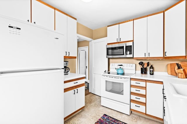 4332 Cooke St, Duluth, MN 55804 - kitchen with white appliances, light countertops, white cabinets, and light tile patterned floors