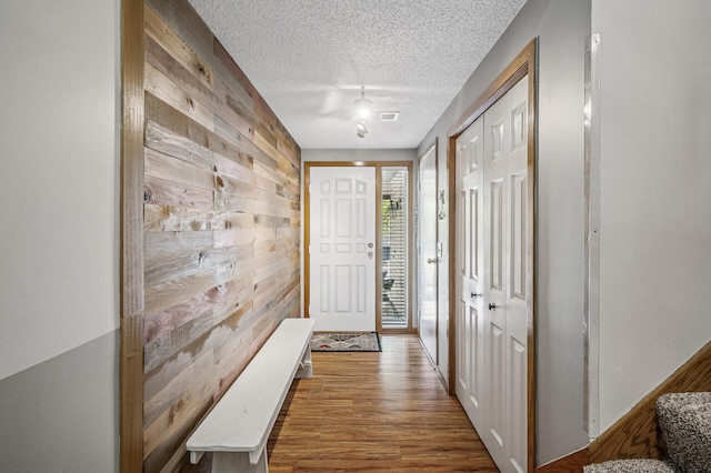 8 110th Ln NW, Coon Rapids, MN 55448 - doorway with wooden walls, a textured ceiling, and wood finished floors