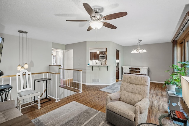 8 110th Ln NW, Coon Rapids, MN 55448 - living room featuring a ceiling fan, wood finished floors, and a chandelier
