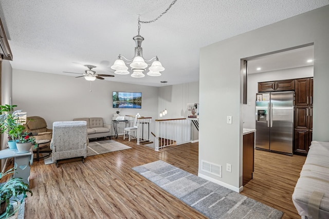 8 110th Ln NW, Coon Rapids, MN 55448 - living area featuring a chandelier, light wood-style flooring, a textured ceiling, and a ceiling fan