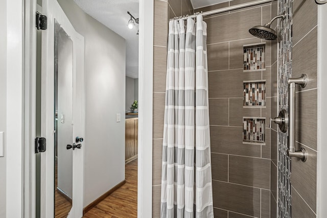 8 110th Ln NW, Coon Rapids, MN 55448 - full bathroom with a tile shower and wood finished floors