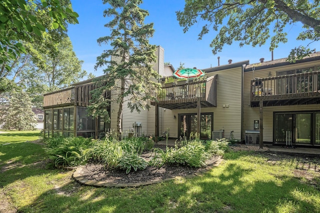8 110th Ln NW, Coon Rapids, MN 55448 - back of house featuring a balcony, a yard, and a chimney