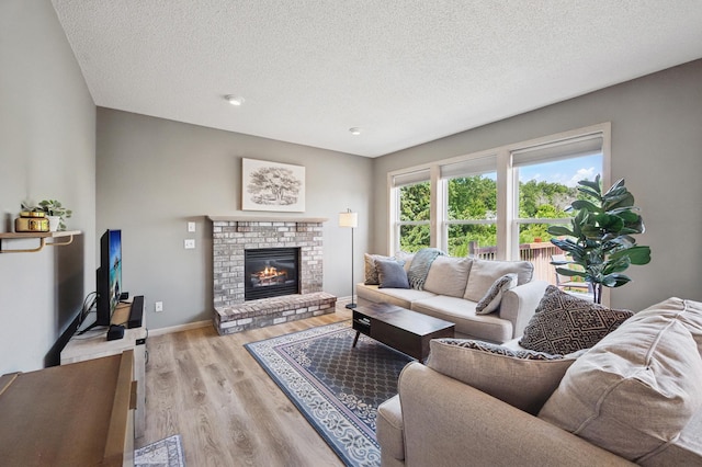 2722 Autumn Woods Dr, Chaska, MN 55318 - living area featuring light wood-type flooring, a textured ceiling, and a brick fireplace