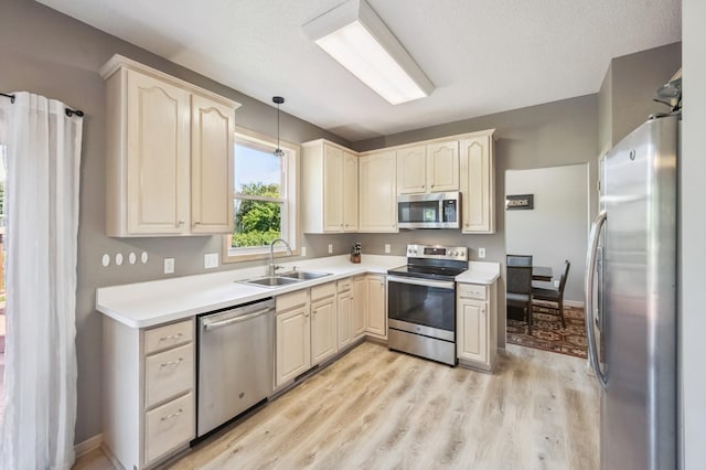 2722 Autumn Woods Dr, Chaska, MN 55318 - kitchen featuring stainless steel appliances, light wood finished floors, pendant lighting, and light countertops