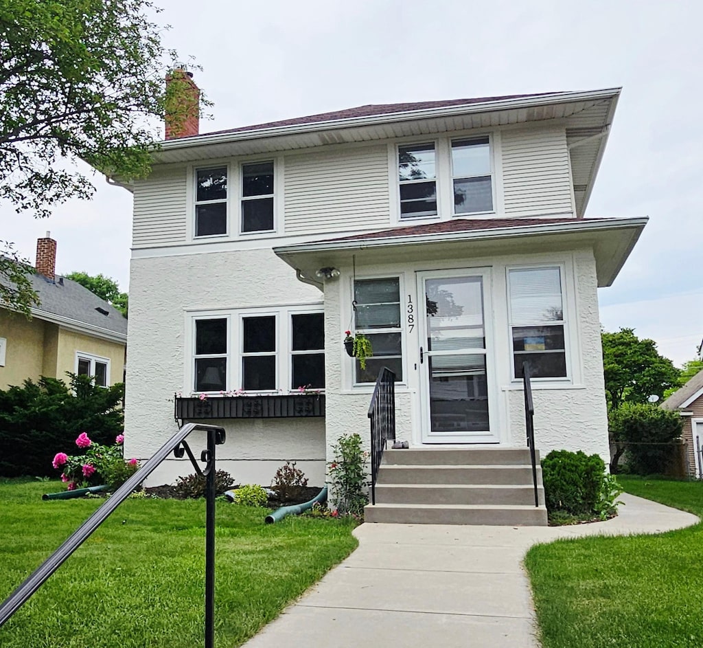 1387 Osceola Ave, Saint Paul, MN 55105 - american foursquare style home featuring a front yard, a chimney, and stucco siding