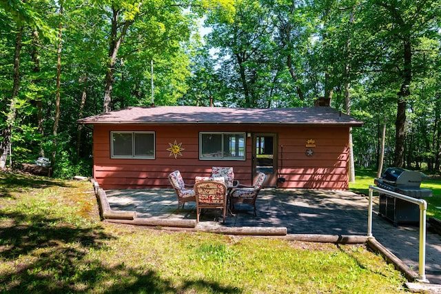 90162 Shady Oak Ln, Kerrick Twp, MN 55756 - back of property with a chimney, a patio, and a lawn