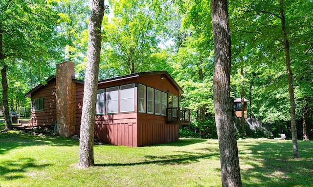 90162 Shady Oak Ln, Kerrick Twp, MN 55756 - view of side of property with a sunroom, a chimney, a lawn, and a deck