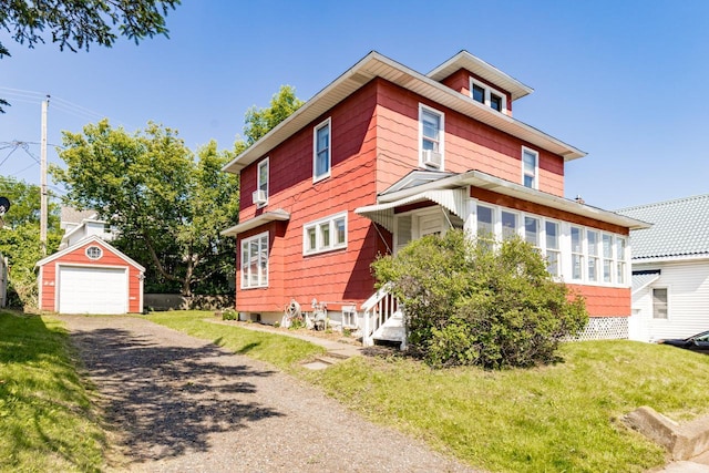41 9th St, Cloquet, MN 55720 - view of front facade featuring an outdoor structure, asphalt driveway, a detached garage, and a front yard