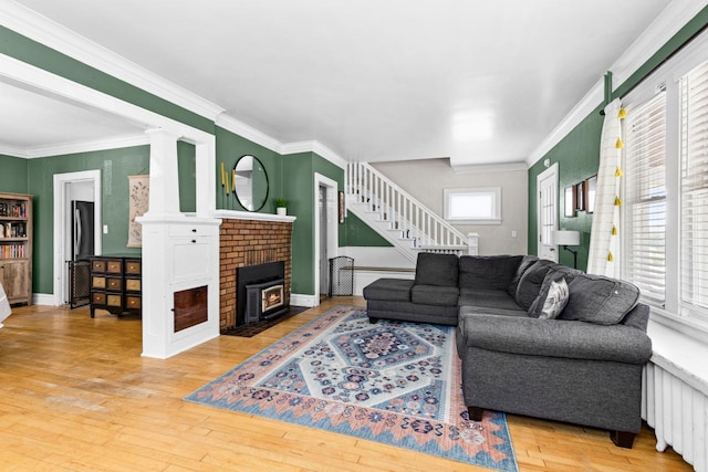 41 9th St, Cloquet, MN 55720 - living area with stairs, a brick fireplace, wood-type flooring, and crown molding