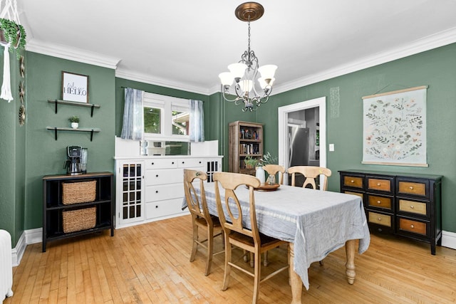 41 9th St, Cloquet, MN 55720 - dining area with a chandelier, light wood-type flooring, and crown molding