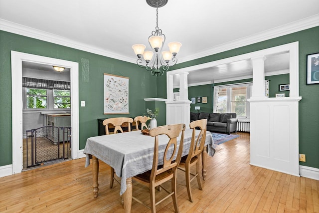 41 9th St, Cloquet, MN 55720 - dining area with ornate columns, crown molding, a chandelier, and light wood-style floors