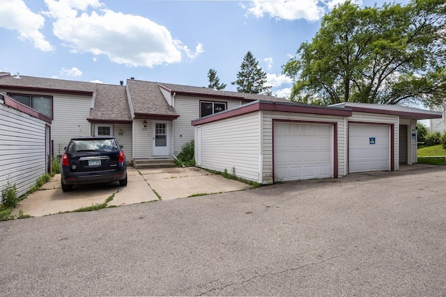 929 40th St NW, Rochester, MN 55901 - view of front of home with an outbuilding, a garage, a shingled roof, and entry steps