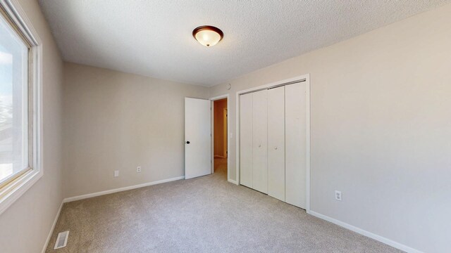 929 40th St NW, Rochester, MN 55901 - unfurnished bedroom with carpet flooring, a closet, and a textured ceiling