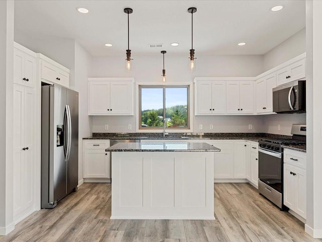 31418 Isabelle Dr, Pequot Lakes, MN 56472 - kitchen with appliances with stainless steel finishes, light wood-type flooring, white cabinetry, a kitchen island, and recessed lighting