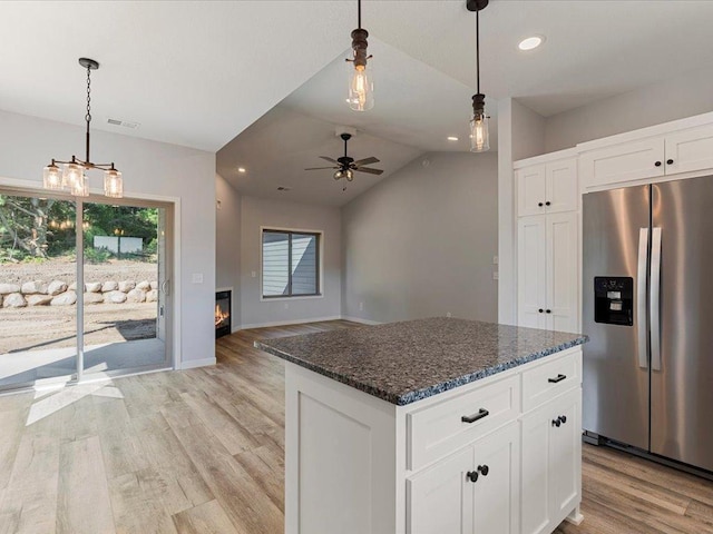 31418 Isabelle Dr, Pequot Lakes, MN 56472 - kitchen featuring stainless steel fridge, light wood-style floors, a ceiling fan, dark stone counters, and white cabinets