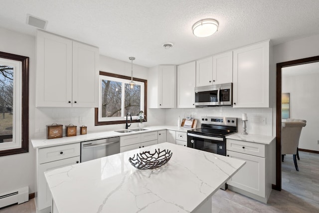 6485 46th Ave SE, Haven Twp, MN 56304 - kitchen featuring appliances with stainless steel finishes, a baseboard heating unit, decorative backsplash, white cabinets, and a textured ceiling