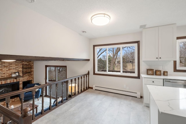 6485 46th Ave SE, Haven Twp, MN 56304 - kitchen with a baseboard heating unit, white cabinetry, light stone countertops, a fireplace, and dishwasher