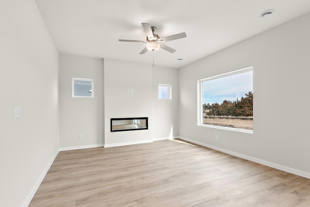 39746 Fallbrook Ave, North Branch, MN 55056 - unfurnished living room with a glass covered fireplace, light wood-style flooring, and ceiling fan