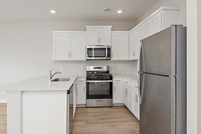 39746 Fallbrook Ave, North Branch, MN 55056 - kitchen featuring stainless steel appliances, a peninsula, light wood-style flooring, white cabinetry, and light countertops