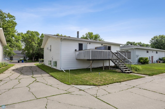 2350 20th Ave S, Fargo, ND 58103 - rear view of house with a deck, concrete driveway, a lawn, and stairway