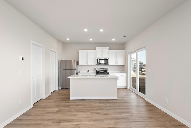 39743 Fallbrook Ave, North Branch, MN 55056 - kitchen with stainless steel appliances, recessed lighting, white cabinetry, light wood-style flooring, and a kitchen island with sink