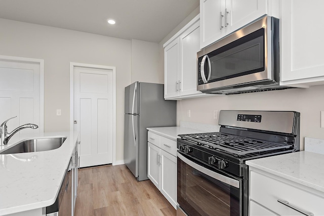 39743 Fallbrook Ave, North Branch, MN 55056 - kitchen with stainless steel appliances, light wood-style floors, white cabinets, light stone countertops, and recessed lighting