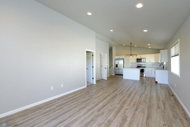 1170 Highland Ln W, West Fargo, ND 58078 - unfurnished living room featuring vaulted ceiling, light wood finished floors, and recessed lighting