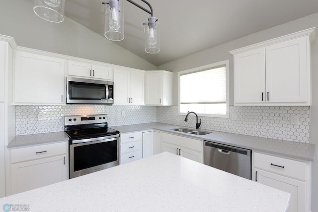 1170 Highland Ln W, West Fargo, ND 58078 - kitchen with stainless steel appliances, white cabinetry, lofted ceiling, backsplash, and decorative light fixtures
