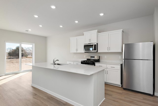 39726 Fallbrook Ave, North Branch, MN 55056 - kitchen featuring stainless steel appliances, white cabinetry, light wood-type flooring, recessed lighting, and an island with sink