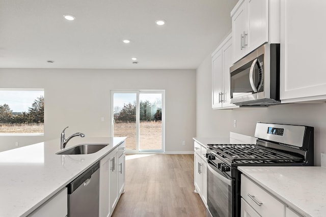 39726 Fallbrook Ave, North Branch, MN 55056 - kitchen featuring stainless steel appliances, light wood-style flooring, white cabinetry, recessed lighting, and light stone countertops
