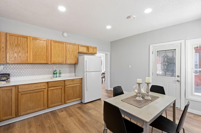 2804 Pillsbury Ave S, Minneapolis, MN 55408 - kitchen featuring freestanding refrigerator, tasteful backsplash, light countertops, light wood finished floors, and recessed lighting